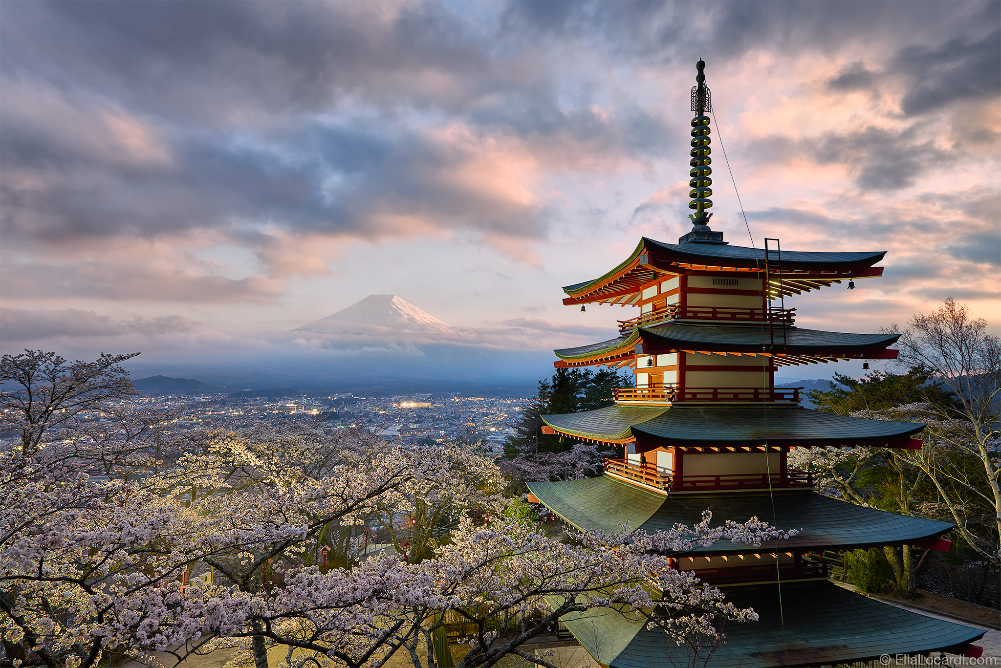 An old pagoda and a sea of cherry blossoms frame the beautiful and timeless shape of Mt. Fuji in Japan.